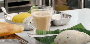 a cup of slightly milky and sweet coffee served at Udupi Kitchen, featuring traditional South Indian brewing style.