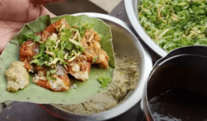 Close-up of Mahaveer Tikkiya’s famous aloo tikki chaat in Ayodhya, featuring spiced peas, green chutney, coriander, ginger, and anardana masala.