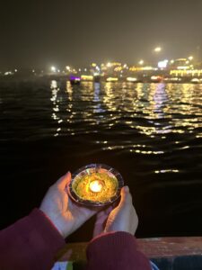 Devotees releasing lit diyas into the Ganges River after Ganga Aarti at Dashashwamedh Ghat.